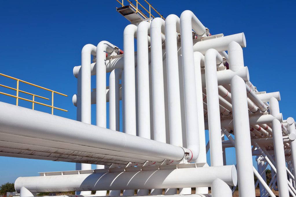 Industrial pipe with gas and oil and water on a background of blue sky